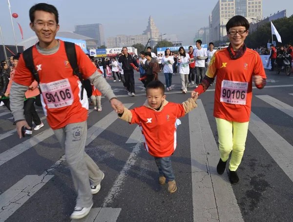 2012年11月18日 在中国东部浙江省杭州市举行的2012年杭州国际马拉松赛上 一对中国夫妇和他们唯一的儿子跑步 — 图库照片
