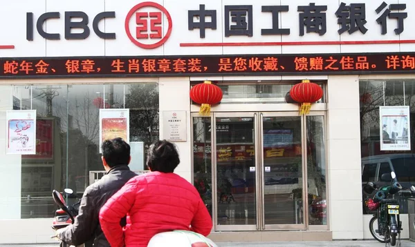 2013年3月24日 两名骑自行车者骑车经过中国工商银行 Icbc 位于中国中部河南省许昌的分行 — 图库照片