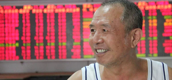 Китайський Інвестор Посміхається Він Дивиться Ціни Акцій Червоний Зростання Цін — стокове фото