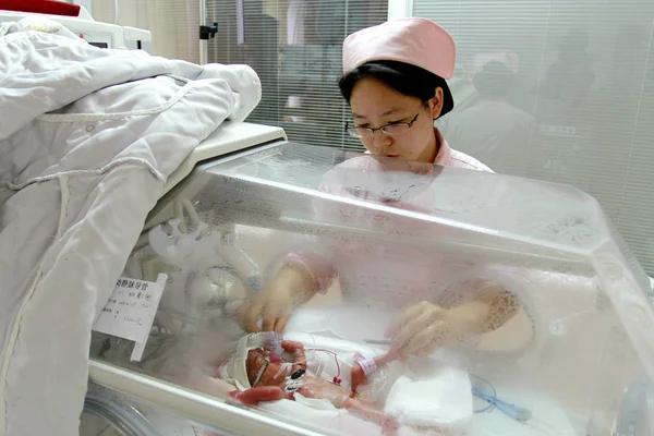2013年10月30日 中国湖南省长沙市湘雅医院Icu的孵化器内 一名护士照顾正在接受治疗的早产女婴 — 图库照片