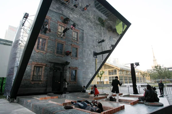参观者在地面上摆出石库门建筑的模型 看着自己被一面45度角竖立的巨大镜子反射 在阿根廷艺术家莱安德罗 埃尔利希在中国上海静安嘉里中心的展览中 18号诺夫 — 图库照片