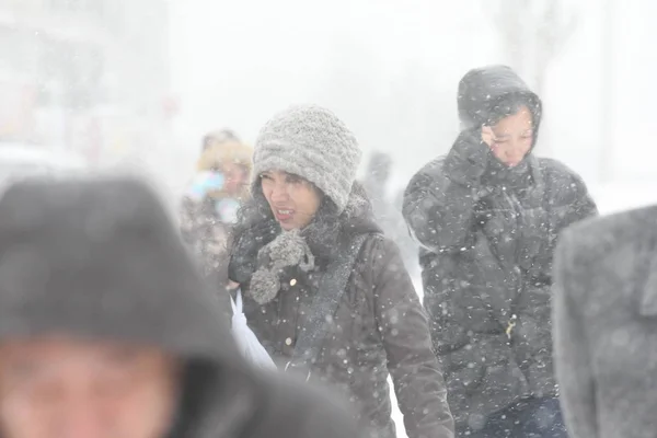 2013年11月18日 在中国东北黑龙江省哈尔滨市 一场暴风雪中 戴帽子的行人在公路上行走 — 图库照片