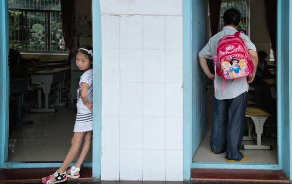 左の若い女子学生は 2013年9月13日 中国中部湖南省大山市の寄宿学校で 両親が教室の外で彼女を迎えに行くのを待っている — ストック写真