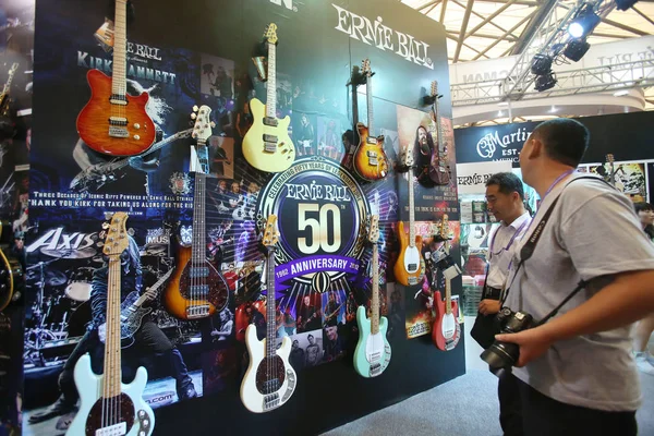 訪問者は 国際楽器エキスポ2013中にアーニーボールの電子ギターを見ます 2013年10月11日 — ストック写真