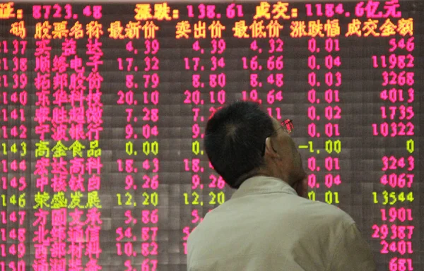 2013年10月21日 在中国东部山东省青岛的一家股票经纪公司 一位中国投资者看了一个屏幕 显示股价 价格上涨为红色 价格下跌为绿色 — 图库照片