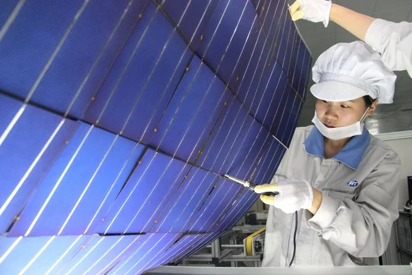2013년 장쑤성 간유시의 공장에서 유럽으로 수출할 태양광 패널을 살펴보고 노동자 — 스톡 사진