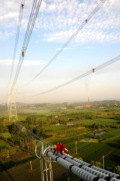 中国の電気技師は 2013年7月31日 中国浙江省東部の湖州市の村で高圧送電線を点検し 修理する — ストック写真