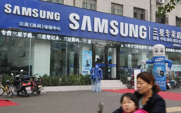 Женщина Несущая Свою Дочь Проезжает Мимо Магазина Samsung Ючжоу Центральная — стоковое фото