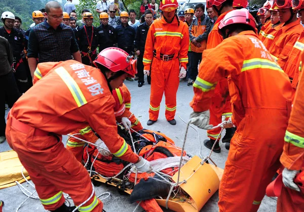 中国の救助隊は 2013年10月9日 中国中部湖南省張家江の天門山国有林公園でジャンプ中に事故で死亡した後 ハンガリーのウィングスーツチラシのヴィクトル コヴァッツの遺体を運ぶ — ストック写真