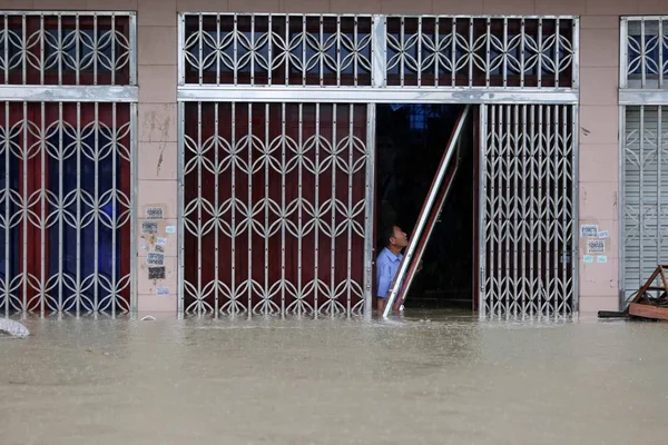 Китаец Закрывает Дверь Своего Затопленного Магазина После Сильных Дождей Вызванных — стоковое фото