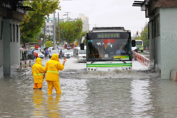2013年10月8日 中国上海台风 Fitow 引发暴雨 中国工人在被洪水淹没的公路上指挥一辆公共汽车 — 图库照片
