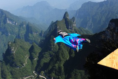 A competitor jumps off the cliff and flies during a training of the second Wingsuit Flying World Championship on Tianmen Mountain in Zhangjiajie, central Chinas Hunan province, 10 October 2012. clipart