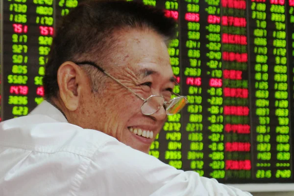 Китайский Инвестор Счастливо Улыбается После Проверки Цен Акции Красный Роста — стоковое фото