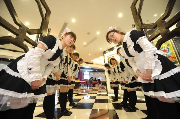 2012년 장쑤성 양저우시의 코스프레 레스토랑에서 하녀복을 웨이트리스가 고객을 맞이하고 — 스톡 사진