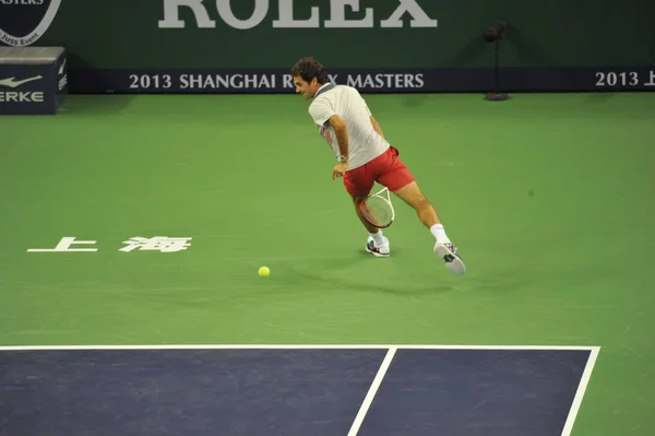 スイスのロジャー フェデラーがオープン上海ロレックス マスターズ 2013 上海の上海七種森林スポーツ市のテニス センターで 2013 日のパフォーマンスの試合で中国の張 にショットを返します — ストック写真