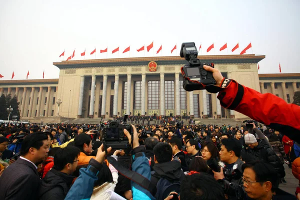 2012年3月5日 在中国北京举行的全国人大第十一届会议第五届会议开幕式前 摄影师和记者在人民大会堂前围住一名副记者 — 图库照片