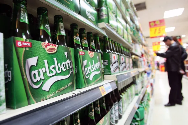 顧客は 2011年3月22日 中国東部江蘇省南通のスーパーマーケットでカールスバーグビールのボトルの隣に飲み物を買い物します — ストック写真