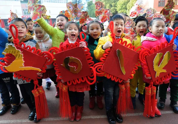 中国の若い学生は 2013年12月31日中国江西省九江市で来年を祝うために2014年の紙切りで中国の結び目を示しています — ストック写真