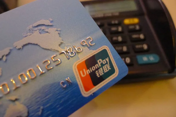 中国の顧客は 2012年1月21日 中国東部山東省青島市のショッピングモールで支払うために中国Unionpayの看板付きのクレジットカードを使用しています — ストック写真