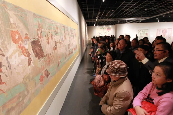 2013年12月28日 在中国东部浙江省杭州市的浙江美术馆举办的敦煌艺术展上 参观者欣赏莫高窟的复制壁画 — 图库照片