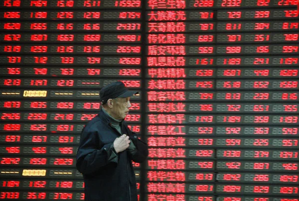 2012年4月5日 在中国东部安徽省淮北市一家股票经纪公司 一位投资者走过显示股价 价格上涨为红色 的屏幕 — 图库照片