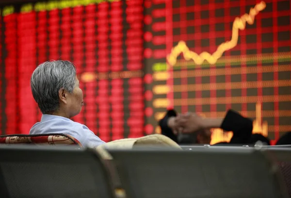 2012 日東中国安徽省淮北の株式仲買の家で 赤の価格上昇 と価格下落のため緑の株式の価格で見る中国人投資家 — ストック写真