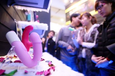 Visitors look at sex toys during the 9th China International Adult Toys and Reproductive Health Exhibition, known as the China Adult-Care Expo 2012 or ADC Expo 2012, in Shanghai, China, 16 March 2012 clipart