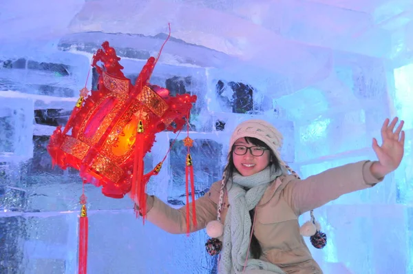 2013年12月26日 中国黒龍江省北東部ハルビン市で開催された第40回ハルビン アイス ランタン アート フェアの試運転中に 氷の彫刻の中に赤い提灯を持ってポーズをとる訪問者 — ストック写真
