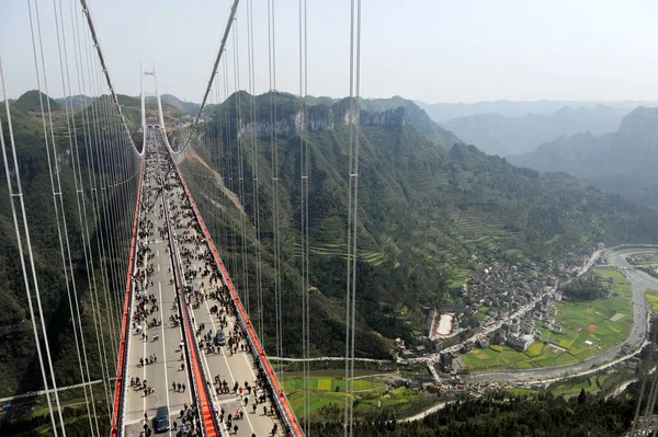 2012年3月31日 游客通过湖南省中部吉首市爱寨镇的艾寨悬索桥 — 图库照片
