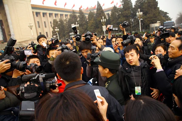2012年3月5日 在中国北京举行的全国人大第十一届会议第五届会议开幕式前 摄影师和记者在人民大会堂前围观中国普拉歌手和副记者谭静 — 图库照片