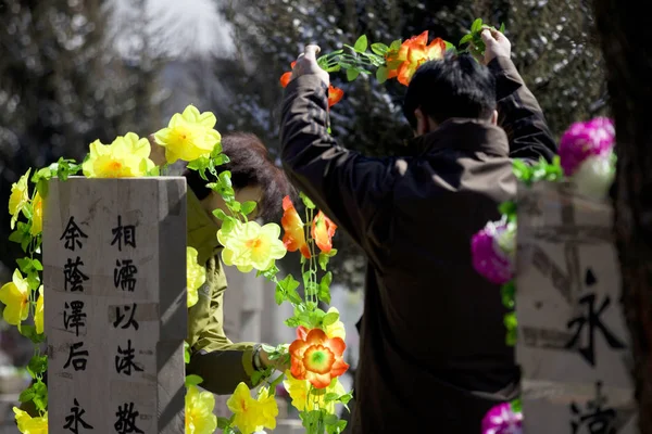 2012年3月31日 在中国东北吉林省长春市 两位居民在清明节前的墓地用鲜花装饰他们的家庭墓地 — 图库照片