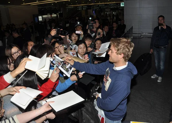 2012年4月11日 德国奔驰车队的德国 车手尼科 罗斯伯格抵达中国上海浦东国际机场后 为中国球迷签名 — 图库照片