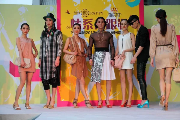 2012年3月3日 在中国南方广东省广州举行的一次促销活动中 穿着高跟鞋的男模与女模特摆姿势 — 图库照片