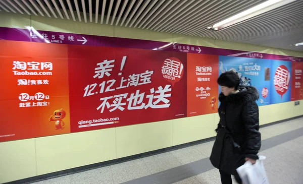 File 歩行者が中国の北京でTaobao Comの広告を通り過ぎる 2011年12月6日 — ストック写真