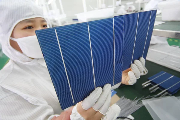 2011年2月21日 中国一名工人在江苏省南通市Eoplly新能源技术有限公司的厂房展示用于制造太阳能电池板的光伏 — 图库照片