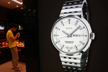 A Chinese customer selects watches in a Mido (a midrange brand of Swatch group) watch store in Shanghai, China, 31 August 2011 clipart
