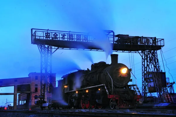 蒸気機関車が中国北部内モンゴル自治区のチフェン市でクレーンの下を通過 2012年1月5日 — ストック写真