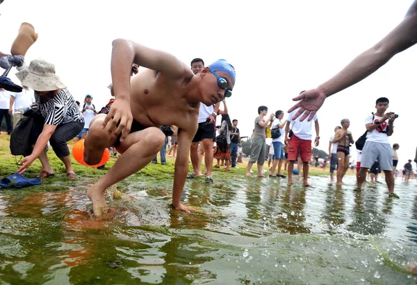 21岁的薛在2012年7月25日横穿山东省青岛市海湾前 右腿在2号泳滩下滑入水中 — 图库照片
