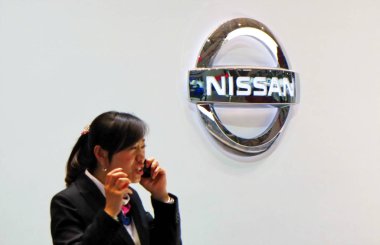  Chinese employee talks on her mobile phone at the stand of Nissan during the 14th Shanghai International Automobile Industry Exhibition, known as Auto Shanghai 2011, in Shanghai, China, 27 April 2011 clipart