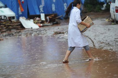 A Chinese doctor moves a carton of medical supplies out of the courtyard of Yiliang County Peoples Hospital hit by a mudslide in the aftermath of the 5.6-magnitude earthquake in Yiliang county, Zhaotong city, southwest Chinas Yunnan province, 11 Sept clipart