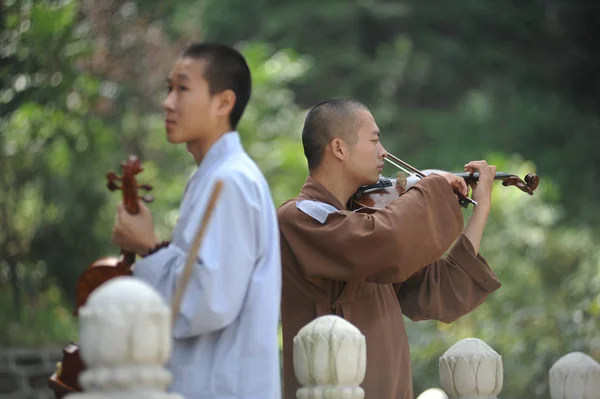 2012年8月24日 中国中部黄冈市红安县天台山天台寺 一名中国佛教僧侣和一名广轩艺术团的修女在训练课上练习拉小提琴 — 图库照片