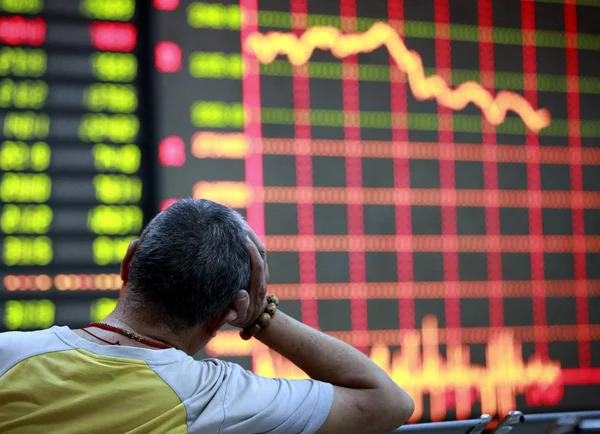 中国の投資家は 株式指数と株式の価格を示す画面の前に載っています 価格上昇のための赤と価格下落のためのグリーン Huaibei 市の株式仲買家で 東中国安徽州 6月4日2012 — ストック写真