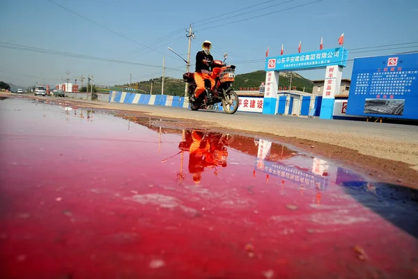 Homem Monta Motociclo Passado Córrego Água Cor Vermelha Contaminada Pelo — Fotografia de Stock