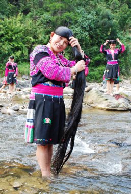 Women of Red Yao minority ethnic group wash their long hair in the river in Huangluo Yao Village, Longsheng county, Guilin city, south Chinas Guangxi Zhuang Autonomous Region, April 2008 clipart