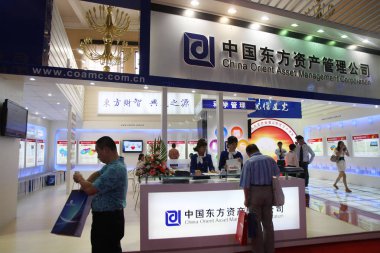 --File--Visitors are seen at the stand of China Orient Asset Management Corporation during a financial fair in Beijing, China, 4 September 2009 clipart