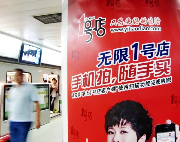 2011年9月27日 上海の地下鉄駅で オンラインショッピングサイトYihaodian Comの広告を通り過ぎる乗客 — ストック写真