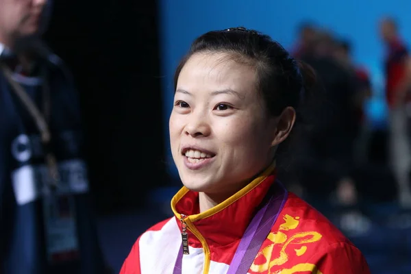 2012年7月28日 在美国伦敦奥运会期间 中国金牌得主王明娟在女子48公斤举重项目上夺冠后 在颁奖仪式上摆姿势 — 图库照片