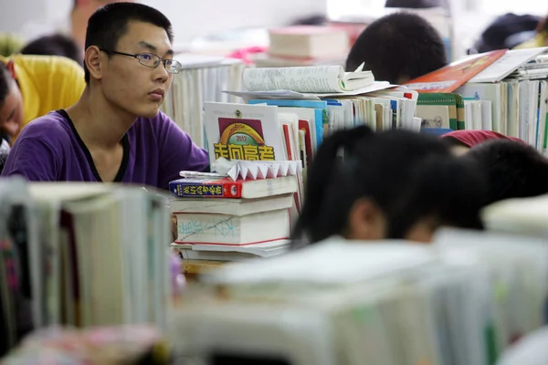 中国人留学生が 2011 日東中国山東省濰坊市の学校で年間の国立大学入学試験の準備で彼らの教科書を確認します — ストック写真