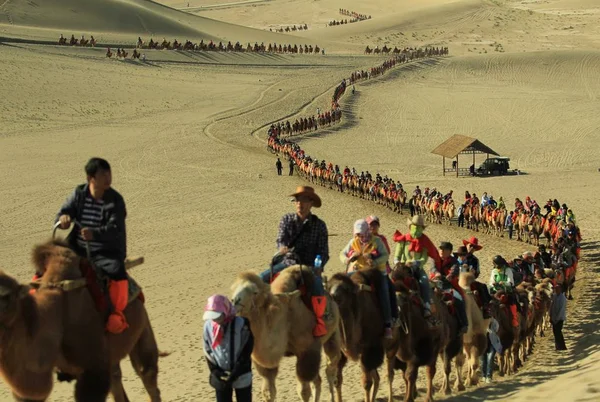 2012年10月3日 在中国甘肃省西北部敦煌的沙漠中骑骆驼的游客和唱沙山风景区 — 图库照片