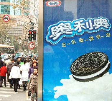 Local Chinese residents walk past an advertisement for Oreo cookies of Kraft in Shanghai, China, 15 February 2007. clipart